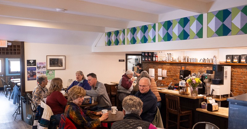 Interior space, bar and seating area full of guests chatting and enjoying their drinks