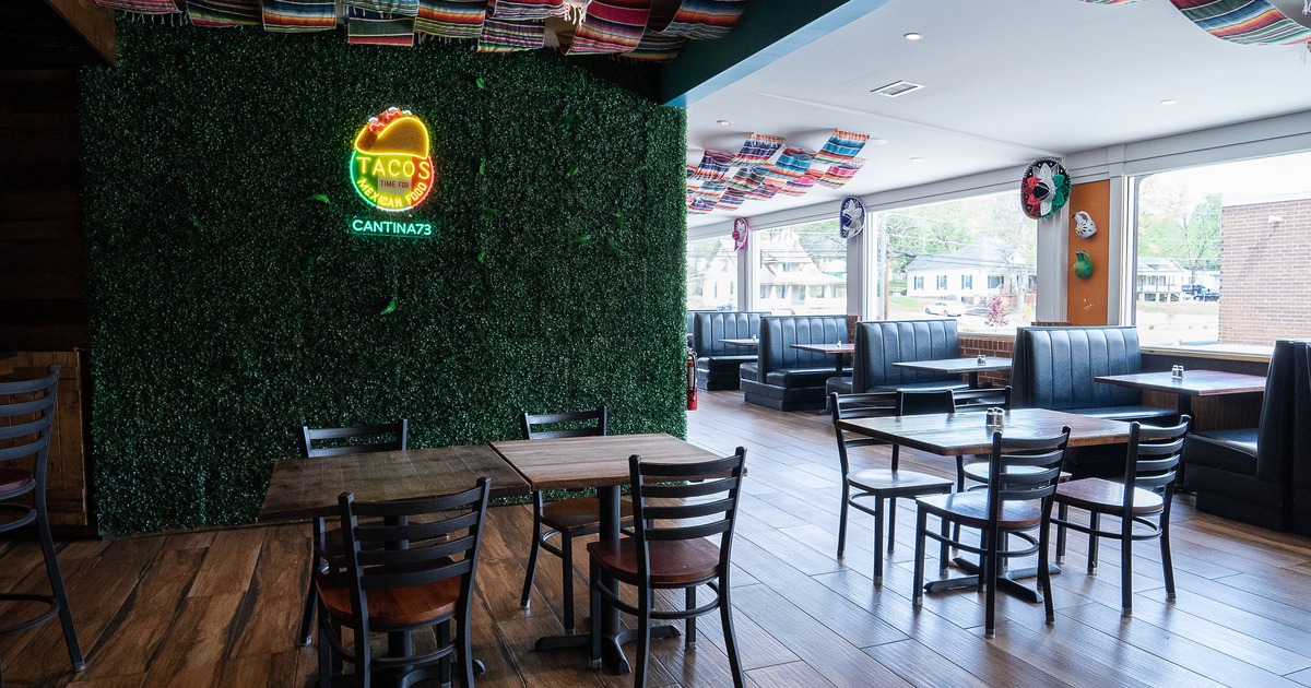 Interior dining area with wooden tables and chairs, and upholstered booths