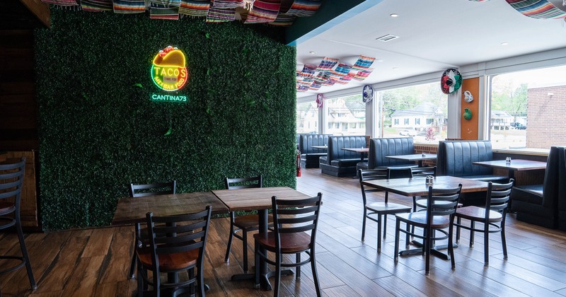 Interior dining area with wooden tables and chairs, and upholstered booths