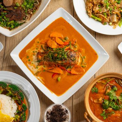 Bowl of Panang Curry served with other menu items, top view.
