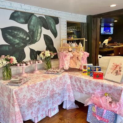 Decorated table with flowers, gifts, and baby clothing.