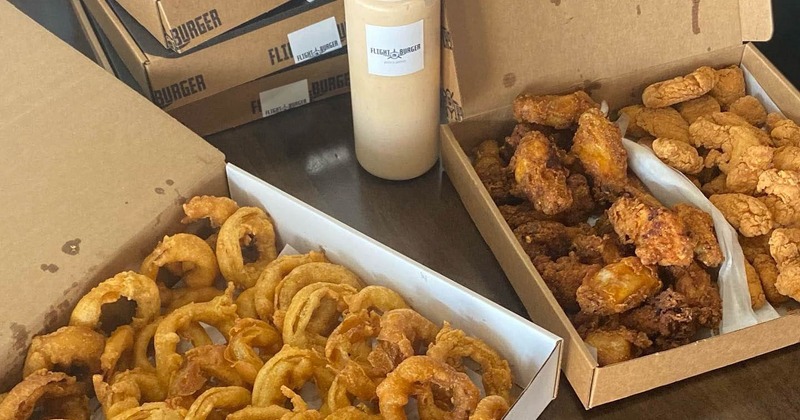 Fried onions and wings in take-away boxes