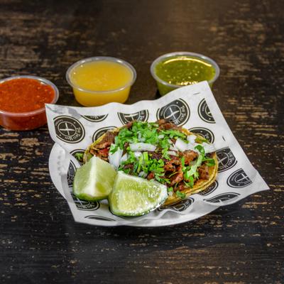 Street taco, with lime and salsa sauces.