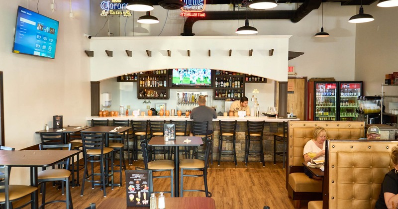 Interior, tables and chairs, bar and bar stools in the back