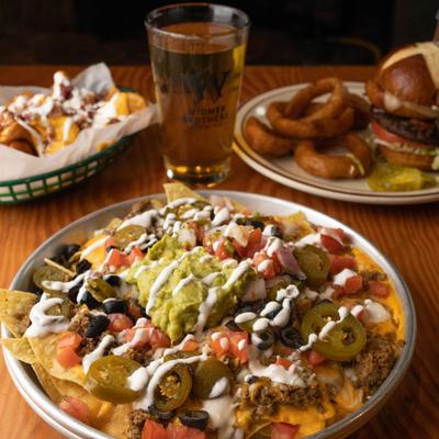 Nachos, with cheese, tomatoes, onions, olives, jalapenos, sour cream, guacamole, and salsa.
