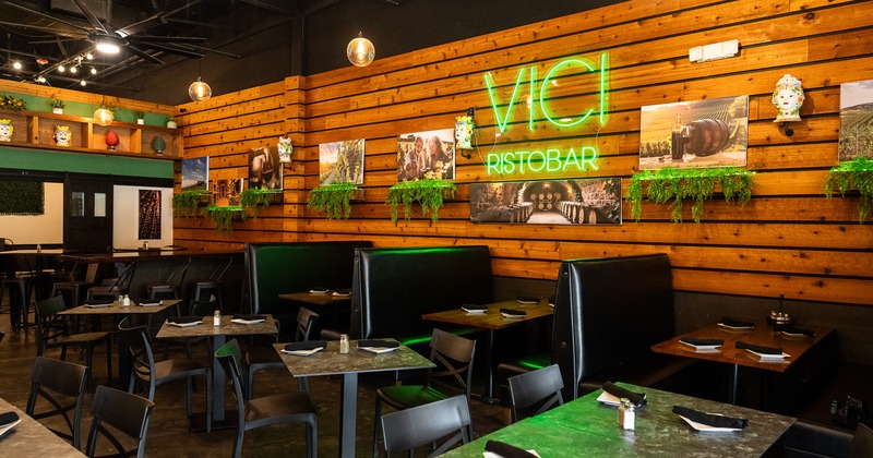 Cozy interior dining area with set dining tables and upholstered booths along the wall