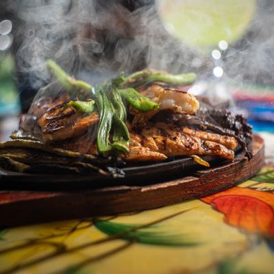 Fajitas a la Mexicana served on a sizzling skillet.