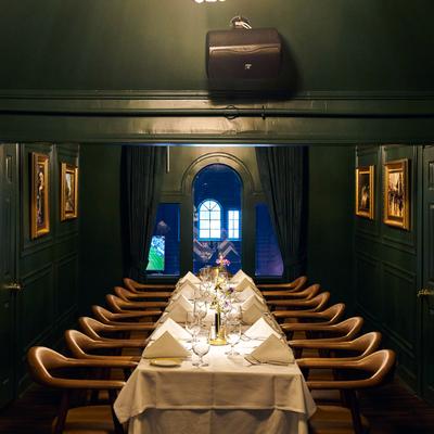 Private dining table set with white linens and leather chairs.