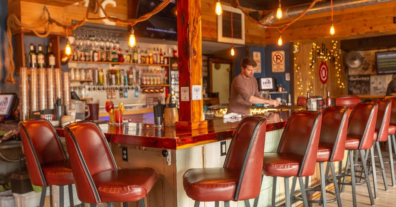 Interior, a bar with leather chairs, a bartender in action