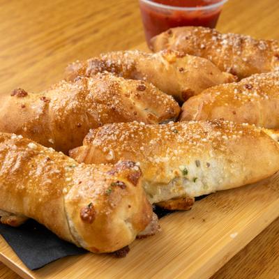 Steak Rolls topped with grated parmesan cheese and served with marinara sauce.