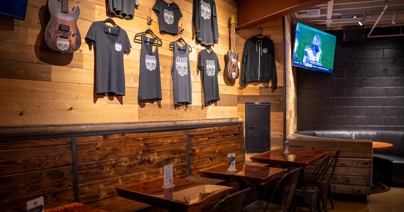 Diner area, table and chairs, merch t-shirts on the wall above