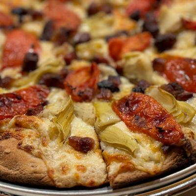 Pancetta & Artichoke pizza, house-made garlic Alfredo, tomato confit, micro fennel.