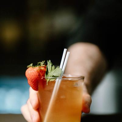A hand holding a Pineapple Cobbler mocktail.