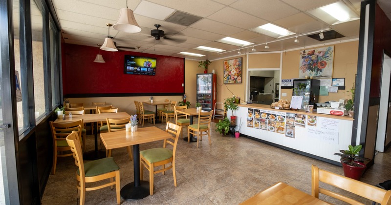 Interior, dining area, tables for two and four, checkout counter, tile flooring