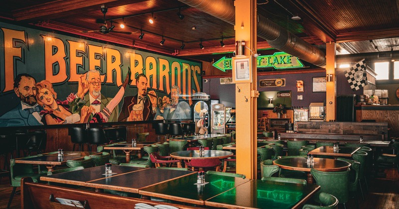 Interior, dining area, tables with chairs ready for guests, wooden pillars, wood coated walls