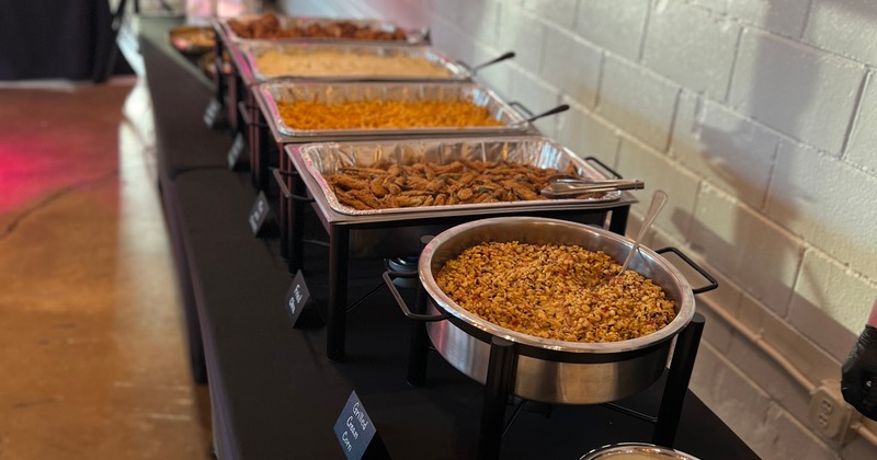 A buffet-style serving line featuring various dishes in chafing dishes