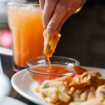 Deep-Fried Wonton neing dipped into a sauce.