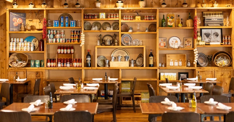 Dining tables and a decorated wall with shelves full of various products