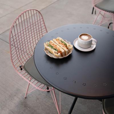 Chicken sandwich served with a cup of latte.