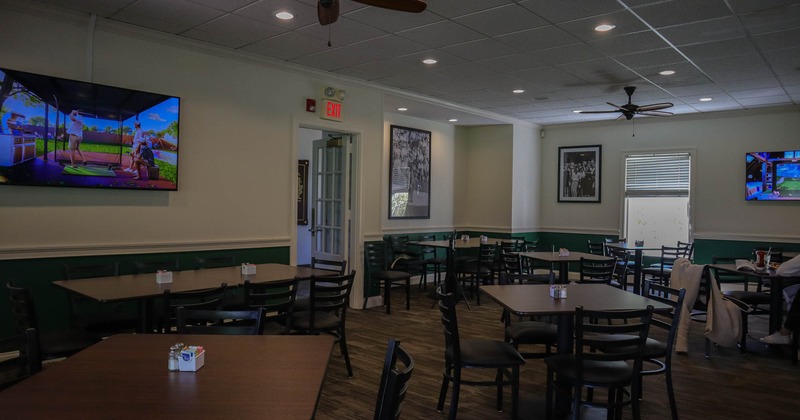 Interior, wide view of seating area, TV screens on the walls