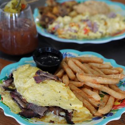Smoked Brisket Omelet served with fries and a side of blackberry-chipotle sauce.