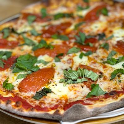 Margherita pizza, house-made red sauce, fresh tomato,  basil, fresh mozzarella.