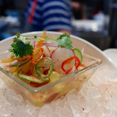 Seafood ceviche served in a glass bowl on a bed of crushed ice.