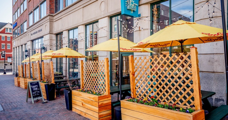 Exterior, partially covered seating area, wooden tables with benches under parasols