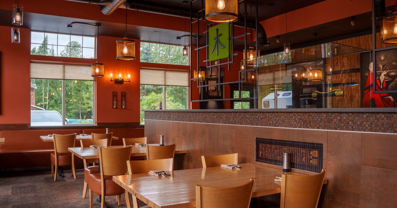 Interior of a restaurant with orange walls, wooden tables, and decorative lighting