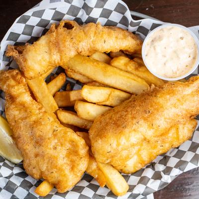 Fish and chips served with dipping sauce on the side.