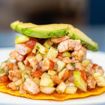 Shrimp ceviche on tostada, topped with avocado.