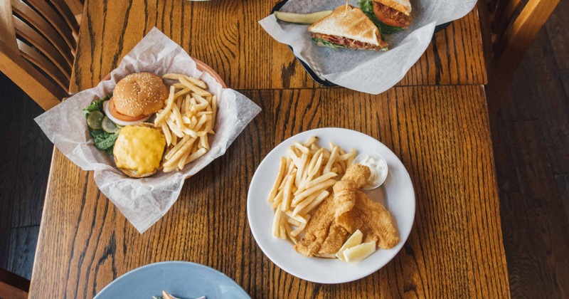 Hamburger and fish and chips served on table