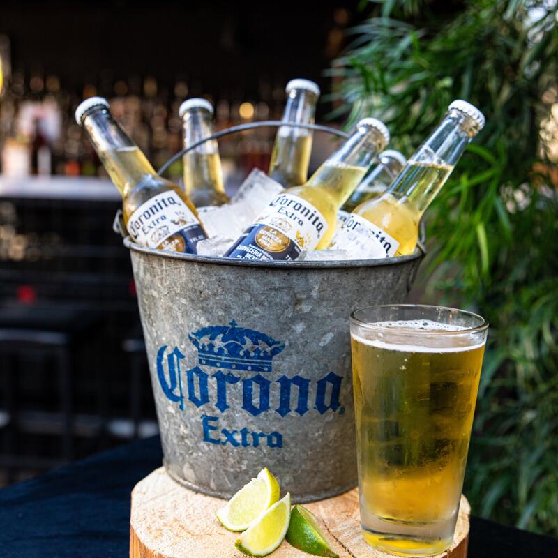 Corona beers on ice and a glass of beer with limes