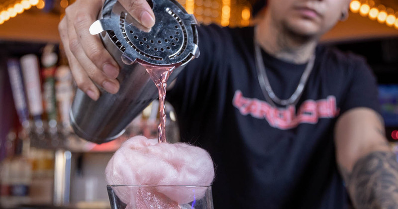 Bartender pouring cocktail into glass