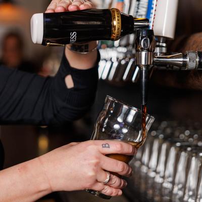 Bartender pouring dark beer from the tap.