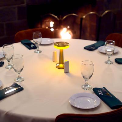 Elegantly set round table with a fireplace in the background.