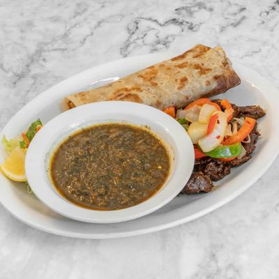 Beef suqar served with a side of savory stew and chapati bread.