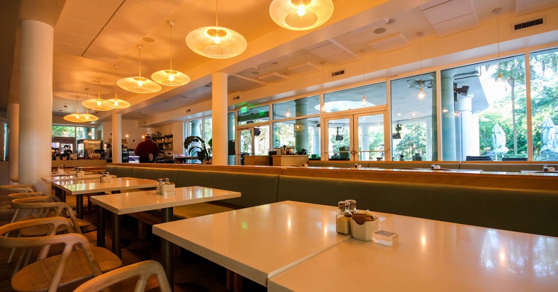 Interior, dining area, tables, chairs and booths, big windows in the back