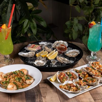 Raw and steamed oysters served alongside fried rice with shrimp and cocktails.