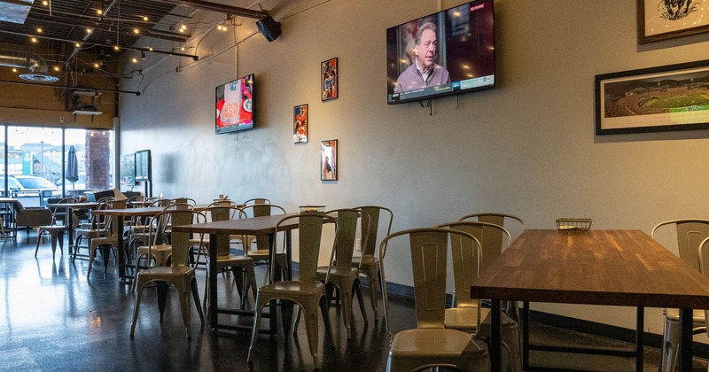 Interior, dining area with two TV's on the wall