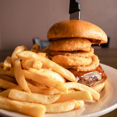 Cheeseburger with BBQ sauce, onion rings, and fries.
