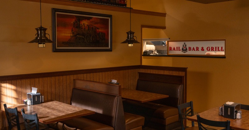 Interior, dining area, seating booths with wooden top tables, low hanging chandeliers
