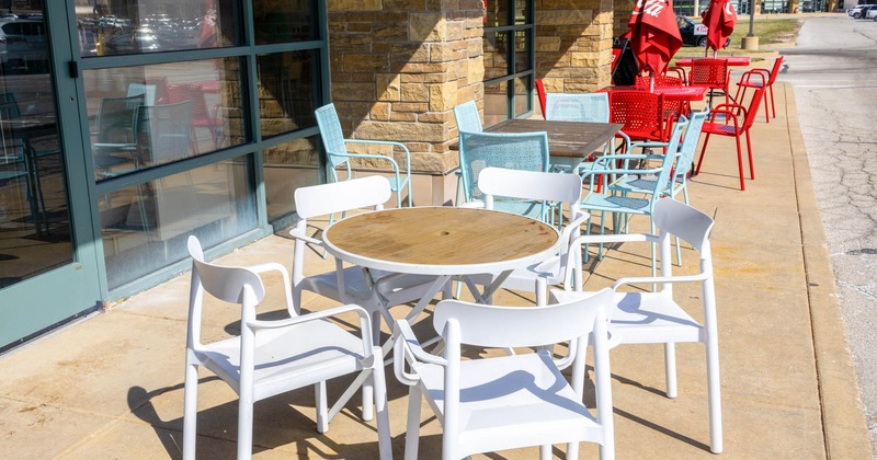Exterior, partially covered seating area, colorful tables with chairs, parasols