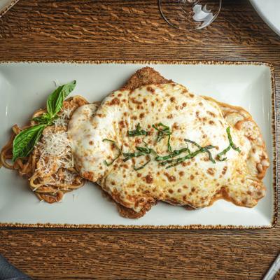 Served chicken parmesan on the table.