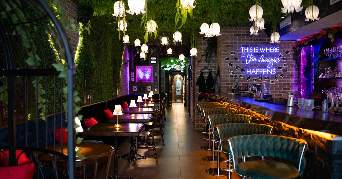 Interior, dining and bar area, wooden top and stone front bar with stools, neon signage