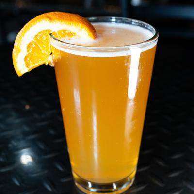 A glass of beer garnished with an orange slice.