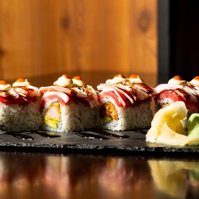 Volcano sushi roll topped with sauces and served with pickled ginger and wasabi.