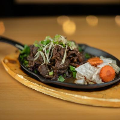 Sizzling beef dish served on the table.