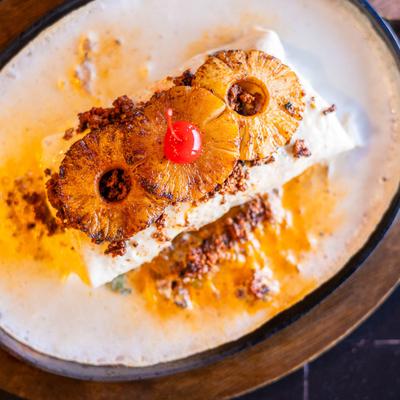 Burrito Tropical topped with pineapple sloces and cocktail cherry.