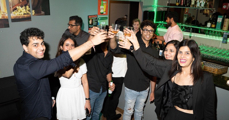A group of guests toasting with drinks in a bar area